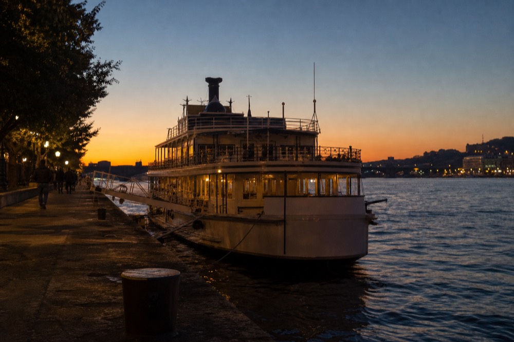 Historical paddle steamer moored at a numbered dock on the Pest embankment at dusk, no text, no logos, no people